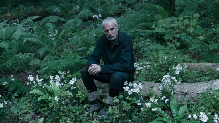 Daniel Day-Lewis sits on a log in the film Anemone.