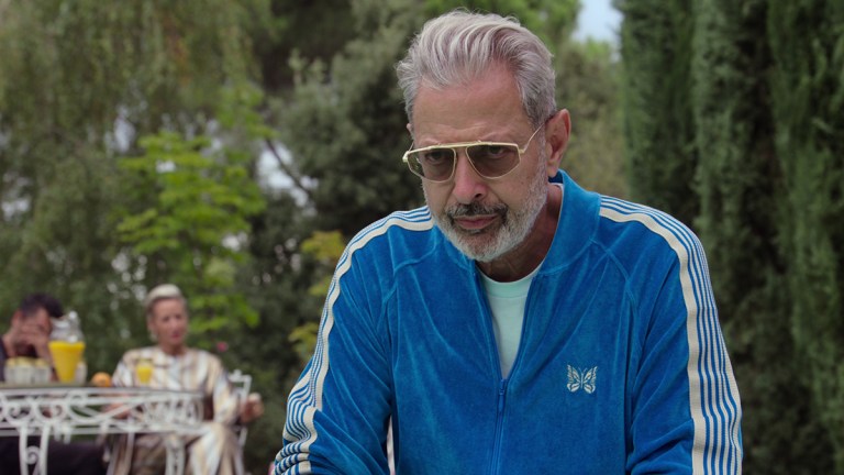 Jeff Goldblum wearing a blue tracksuit and sunglasses in Netflix's KAOS